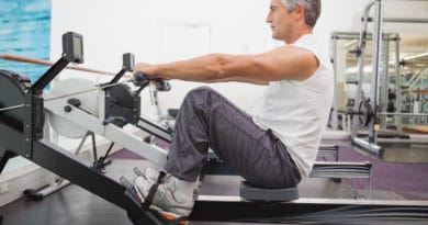Midaldrende mand træner konditionstræning i en romaskine